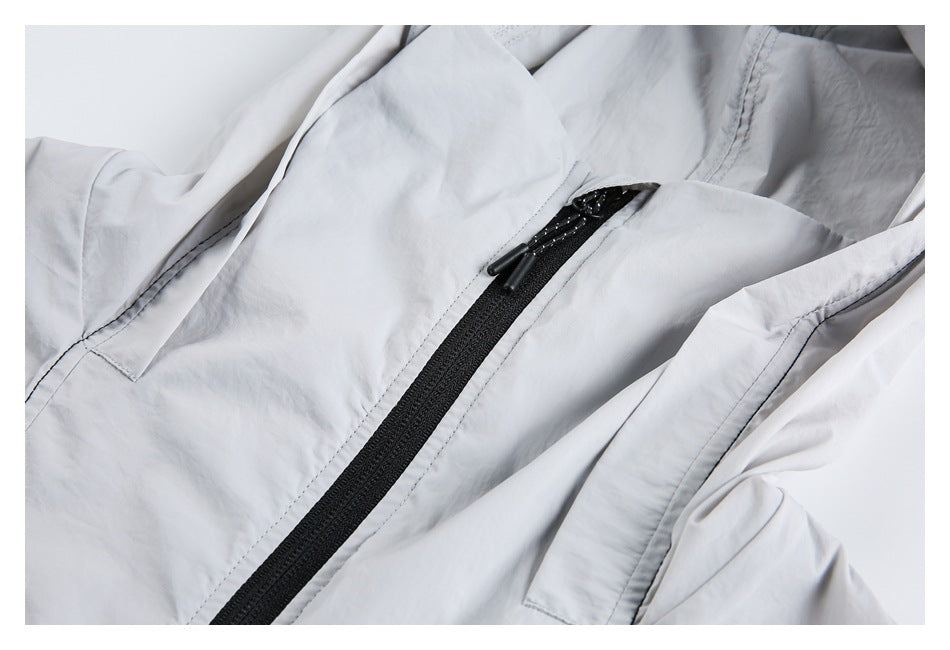 Close-up of a light gray jacket's black front zipper and stitched panels.