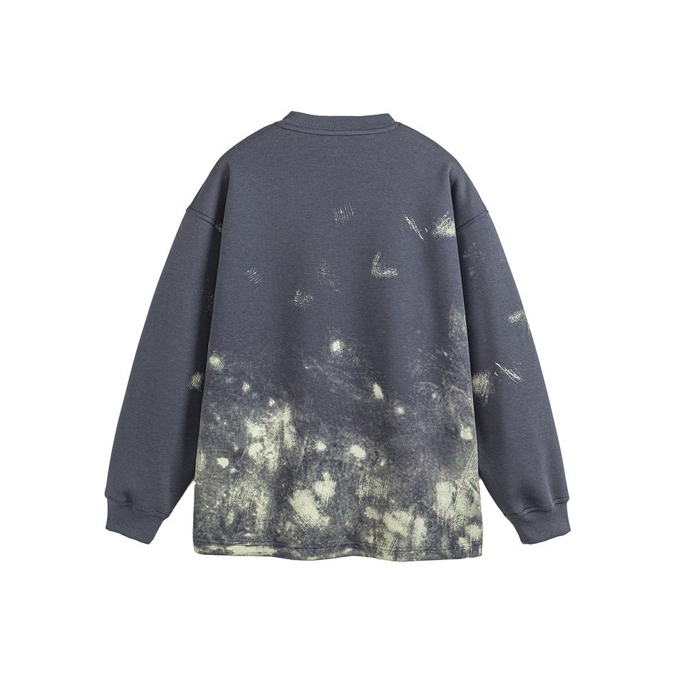 Back view of a charcoal crewneck sweatshirt with pale distressed splashes concentrated across the lower half.