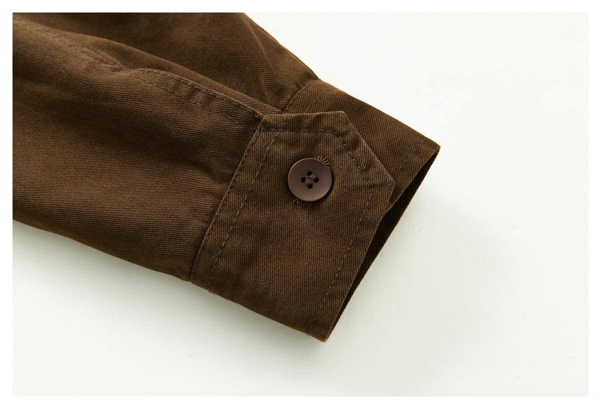 Close-up of a dark brown jacket sleeve cuff with a buttoned strap and visible stitching.