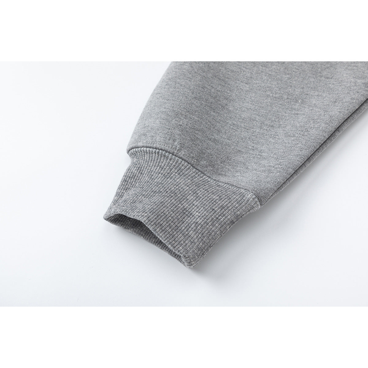 Close-up of a gray hoodie sleeve ending in a ribbed cuff.
