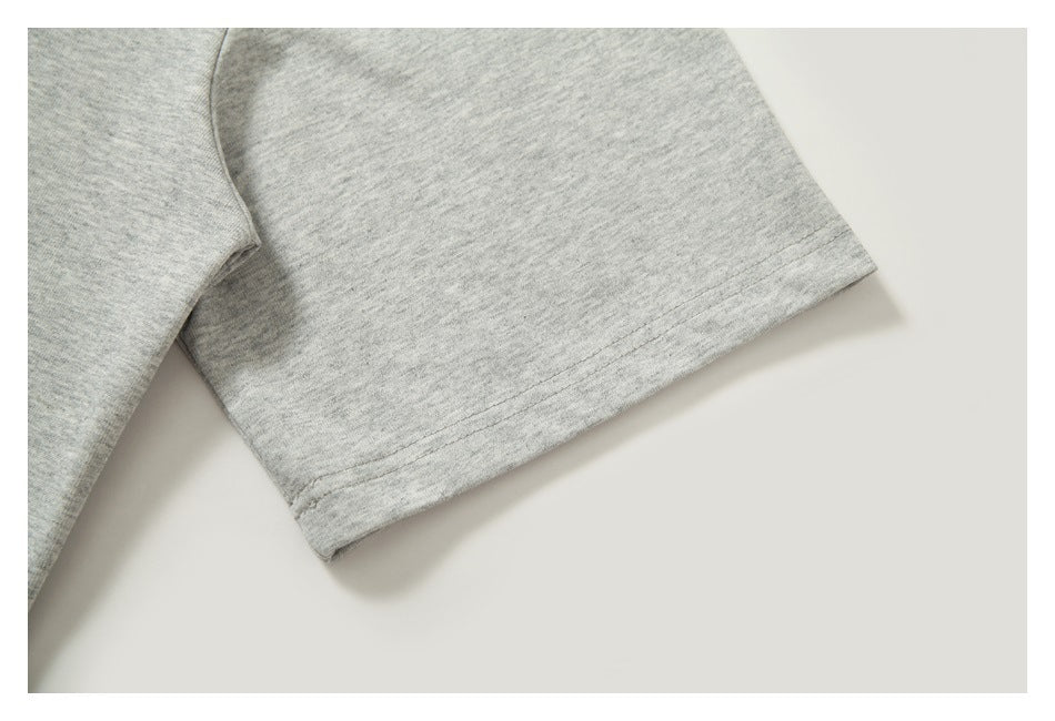 Close-up of a short sleeve and stitched hem on a heather-gray shirt.
