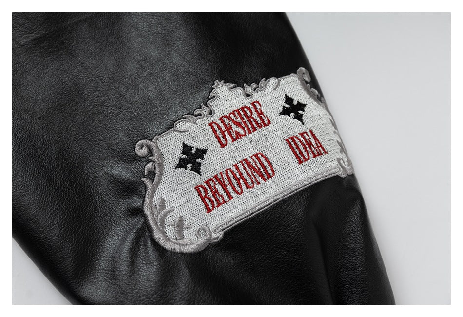 Close-up of a black jacket sleeve with an ornate embroidered patch reading “DESIRE BEYOND DEATH.”