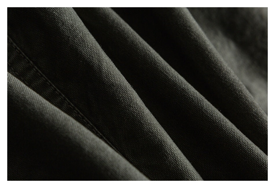 Macro view of the dark olive trouser fabric and stitched seam.
