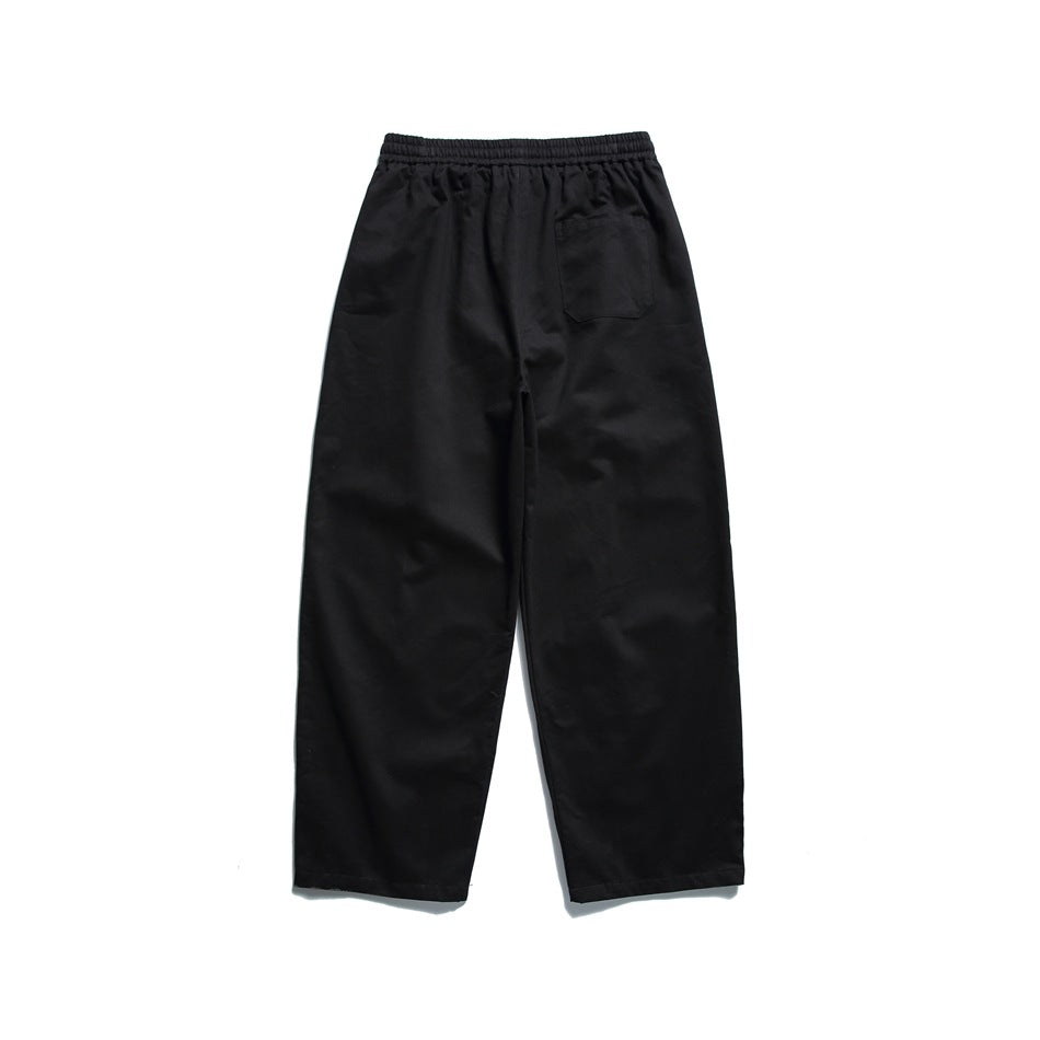Black wide-leg pants back view with elastic waistband and a single patch pocket