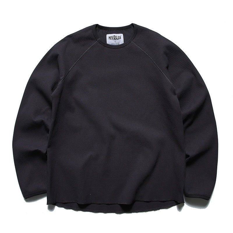 Dark gray waffle-knit long-sleeve crew-neck top with raglan sleeves and raw curved hem, flat front view
