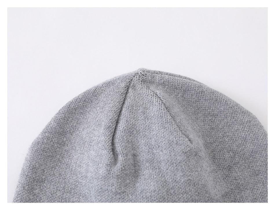 Close-up of the crown seams and knit texture on a light gray beanie.