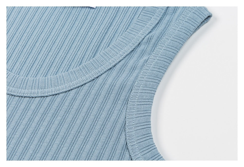 Close-up of the light blue ribbed top's neckline and armhole binding.