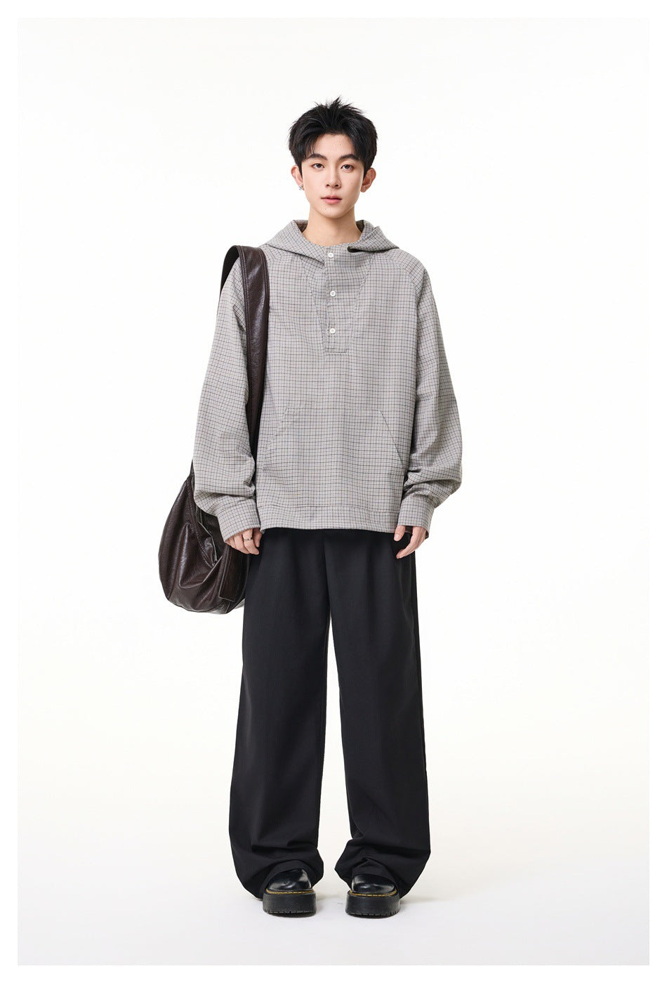 Model wearing gray checked hooded pullover with black wide-leg trousers, black boots and a brown shoulder bag