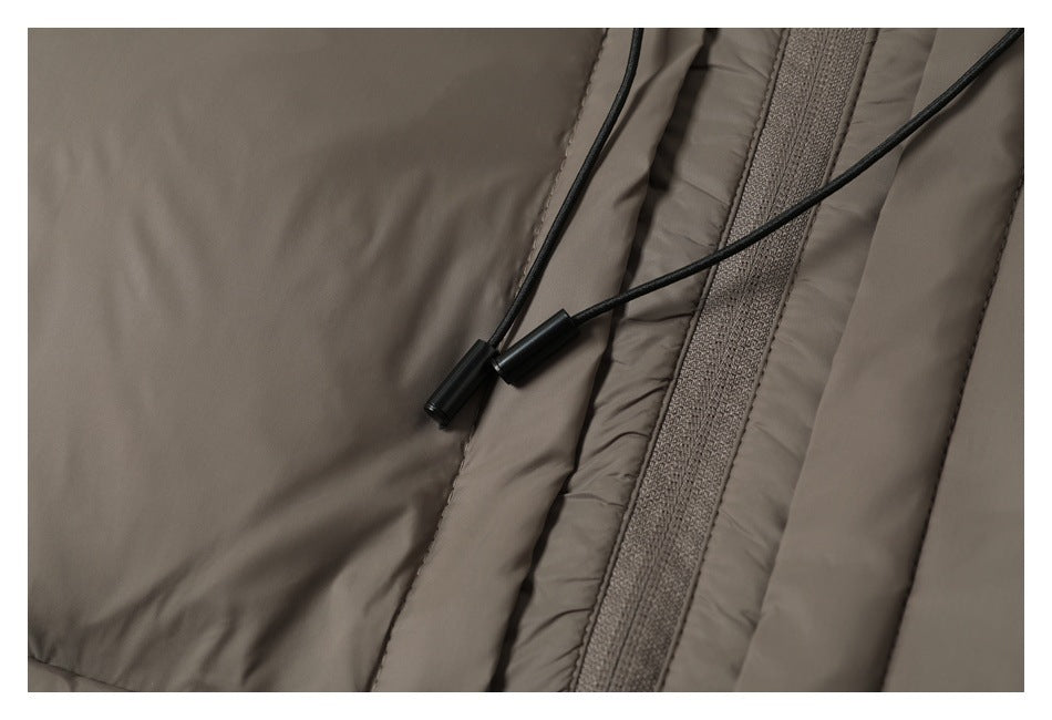 Close-up of the taupe jacket front zipper and black drawcord ends.