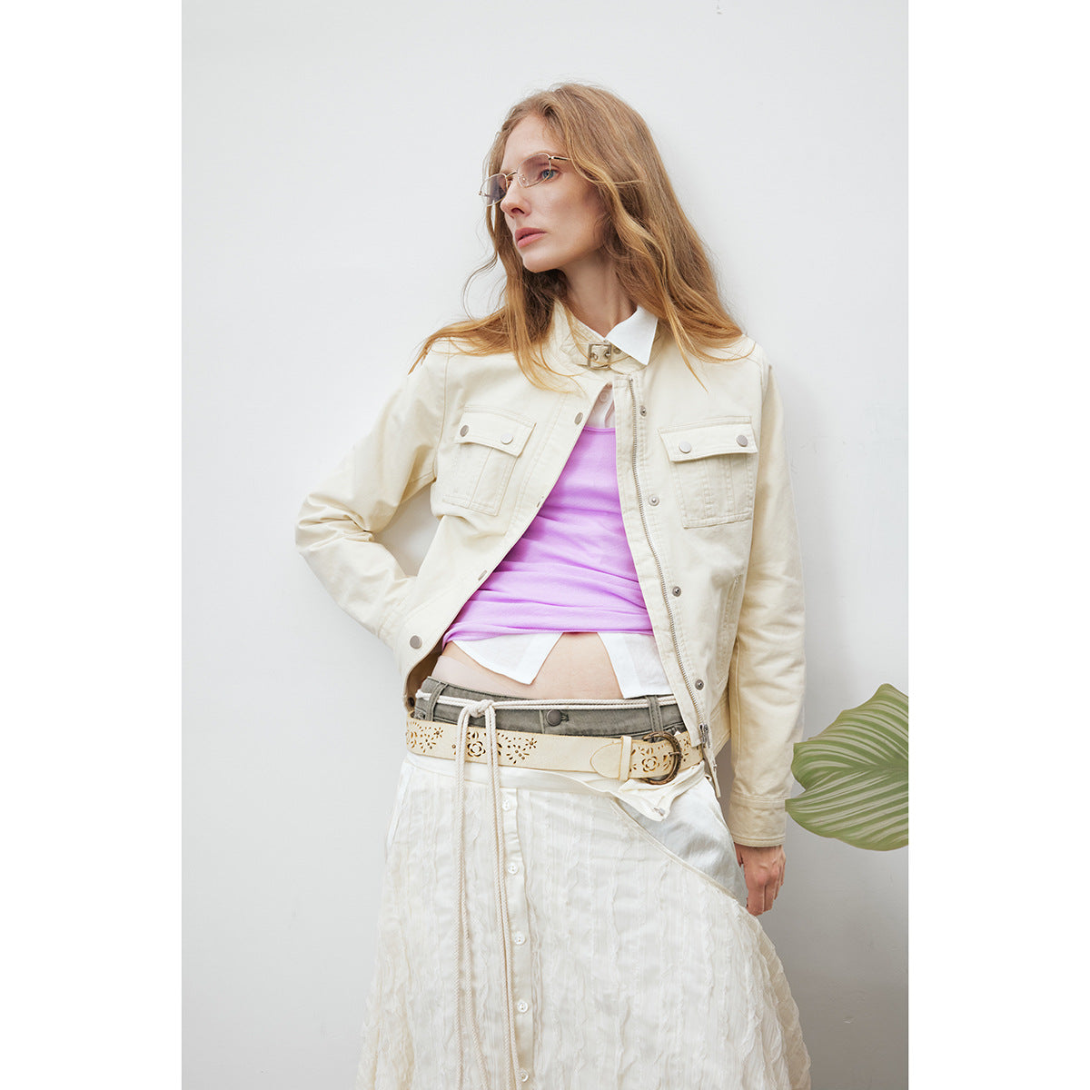 Close view of a model wearing an ivory utility jacket with flap pockets over a lilac top.