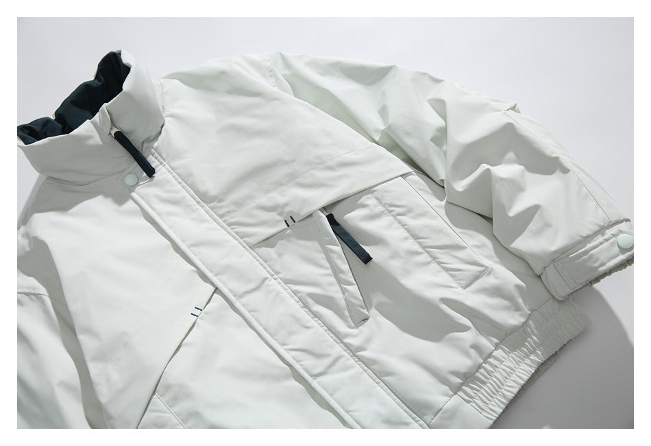 Angled front view of a white jacket laid flat, showing its zip closure, flap pockets, high collar, and gathered hem.