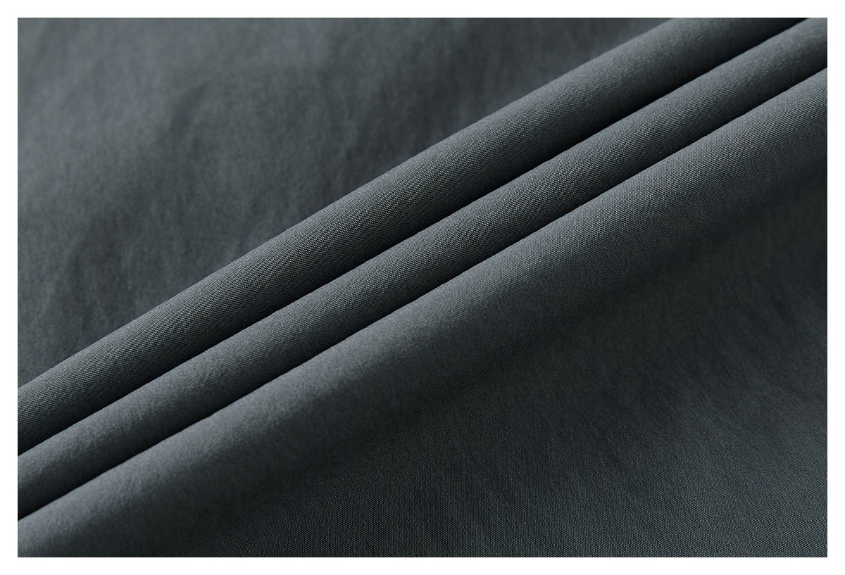 Close-up of charcoal-gray fabric folded to show its surface and drape.