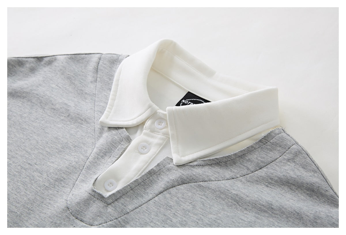 Close-up of a heather gray polo shirt's white collar and three-button placket.