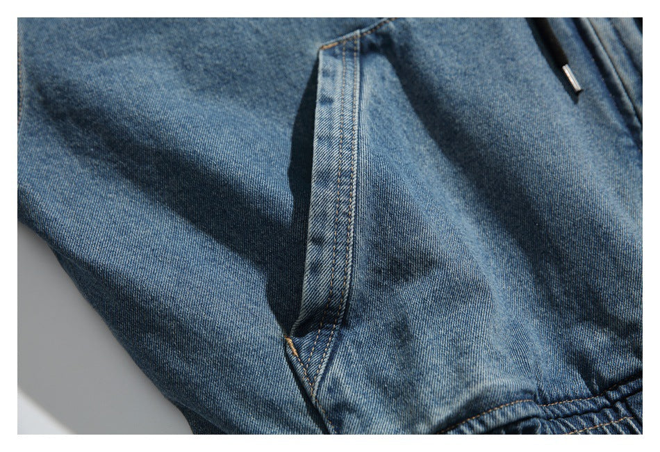 Close-up of the blue denim hoodie's side-entry pocket and contrast stitching.