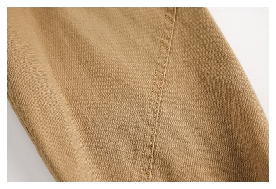 Close-up of camel-brown garment fabric with a vertical double-stitched seam.