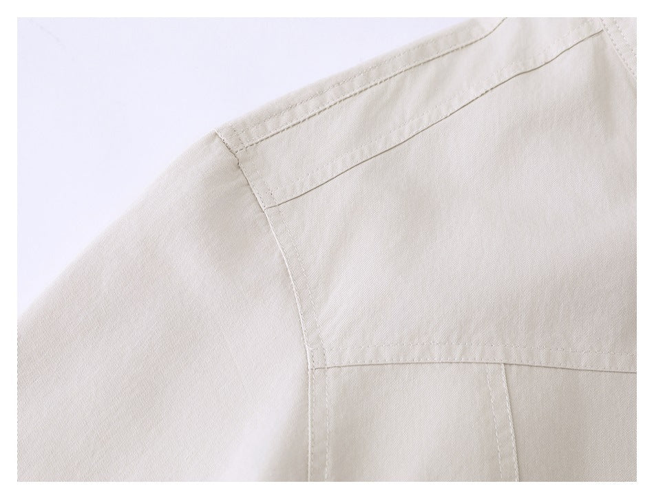 Close-up of the beige jacket's shoulder and back yoke seams.