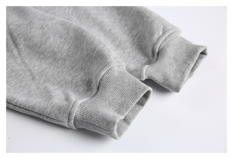 Close-up of two heather-gray sweatshirt sleeves with wide ribbed cuffs.
