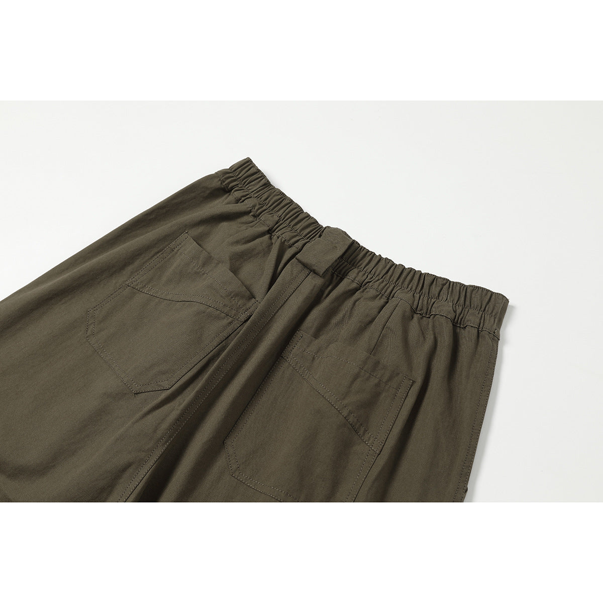 Close-up of dark olive trousers showing the elasticated back waistband and two rear pockets.