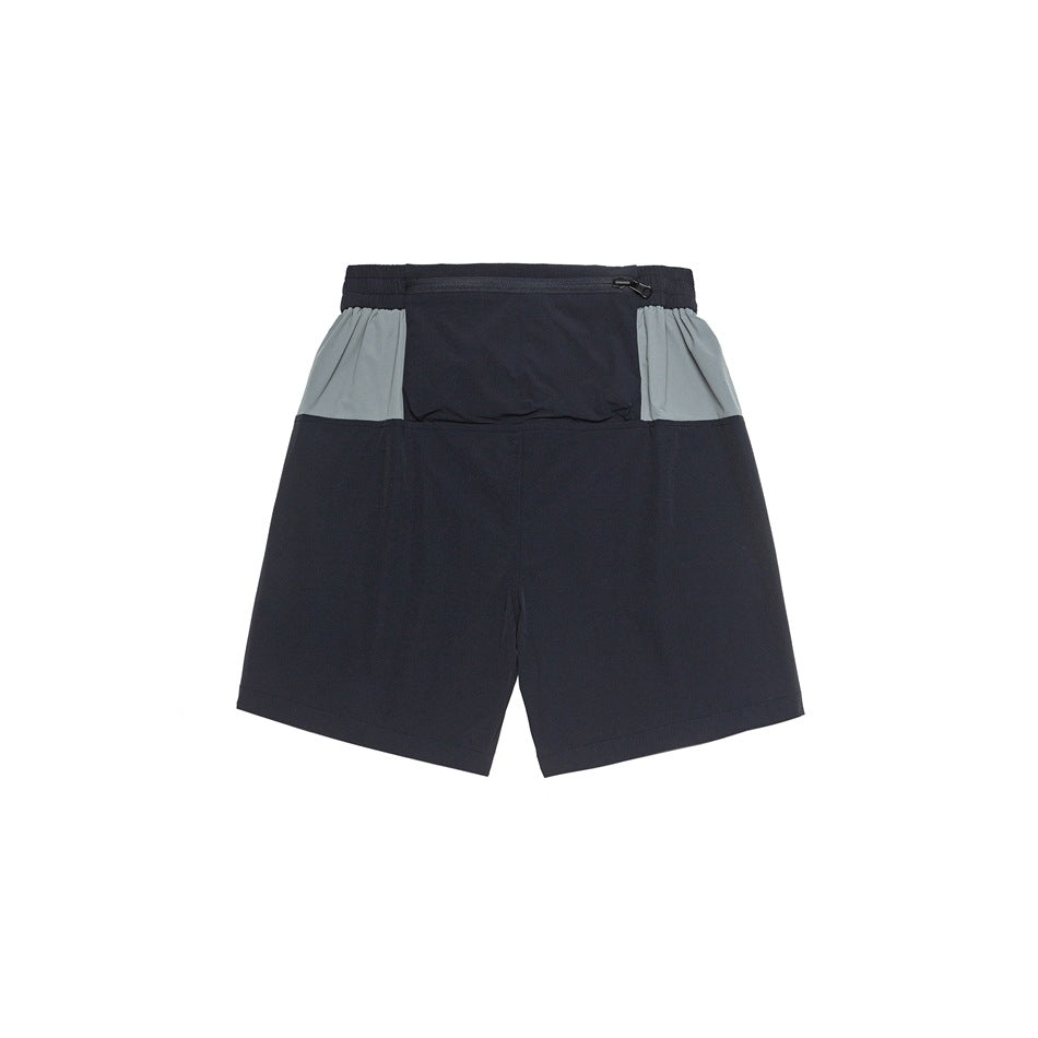 Back view of navy shorts with gray side panels and a zippered back waist pocket on white background