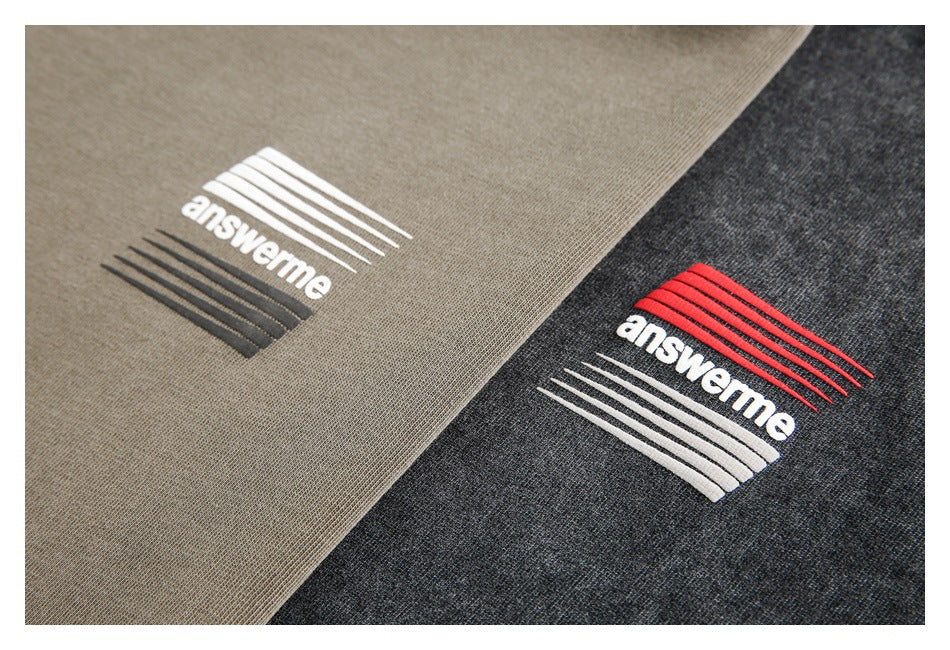 Close-up of beige and charcoal fabric panels with embroidered answerme graphics in contrasting colors.