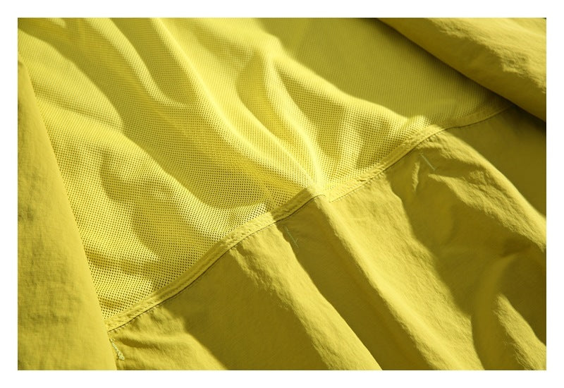 Close-up of yellow mesh lining and the adjoining smooth fabric inside the jacket.