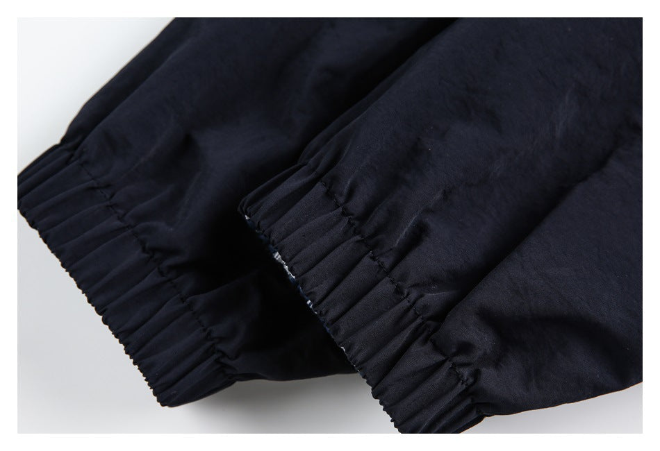 Close-up of two gathered elastic cuffs on the dark navy jacket.