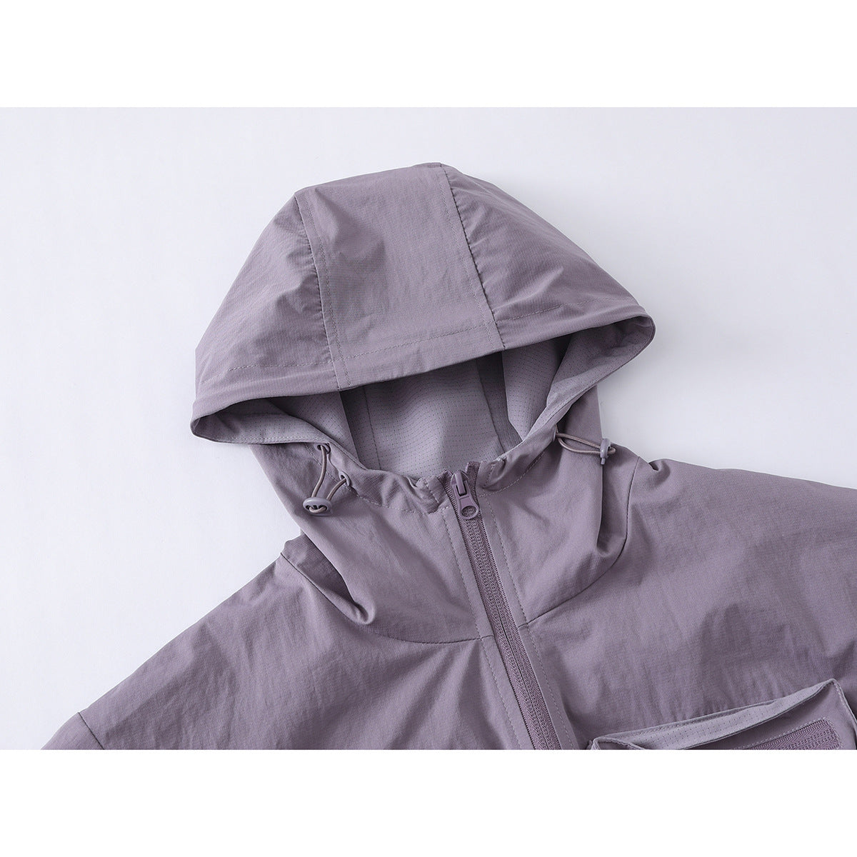 Close-up of a muted lavender-gray jacket hood, drawcords, lining, and front zipper.
