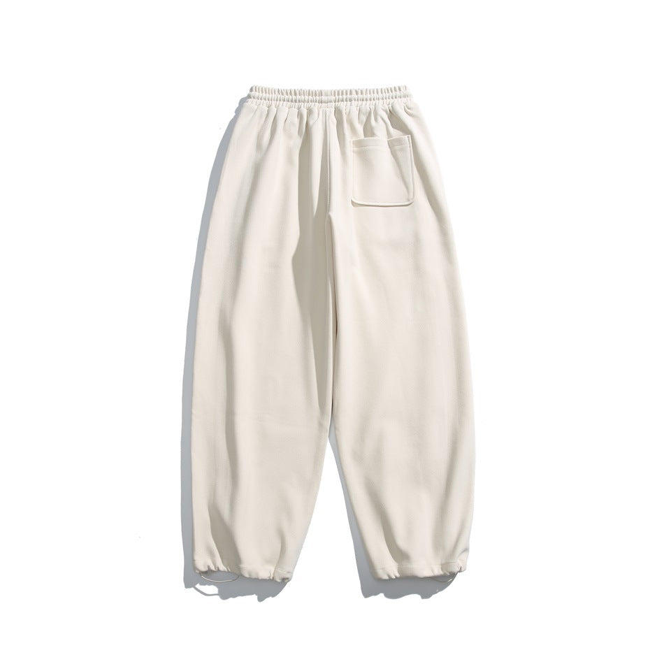 Off-white relaxed-fit pants with an elastic waist, one patch pocket, and gathered ankle cuffs, shown flat.