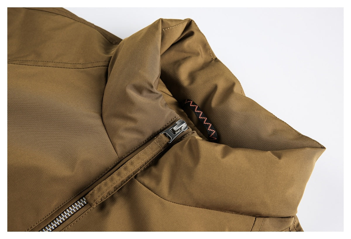 Close-up of a brown jacket collar, silver zipper, and black loop with a pink zigzag accent.