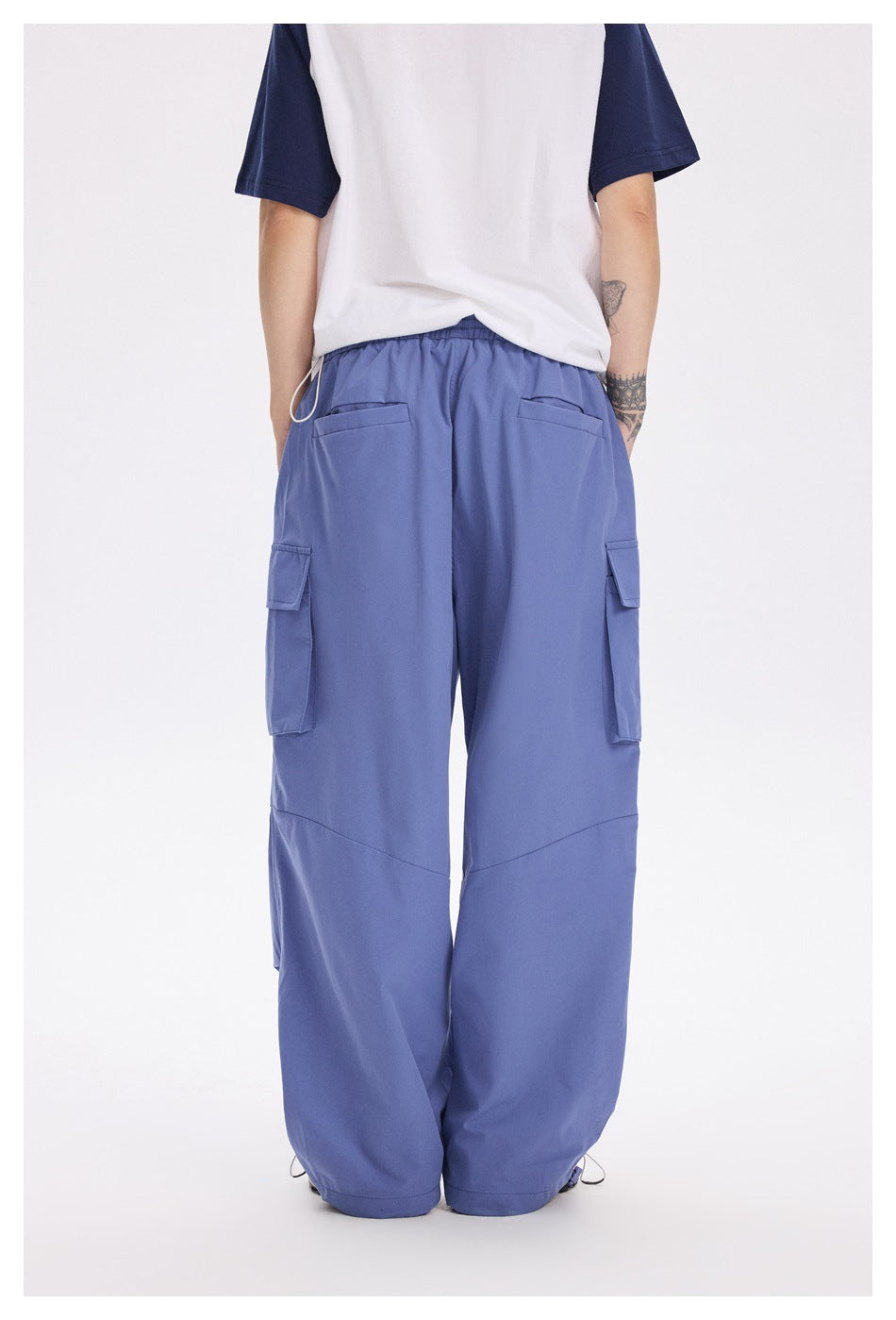 Back view of a model wearing periwinkle cargo pants with two rear pockets and side cargo pockets.