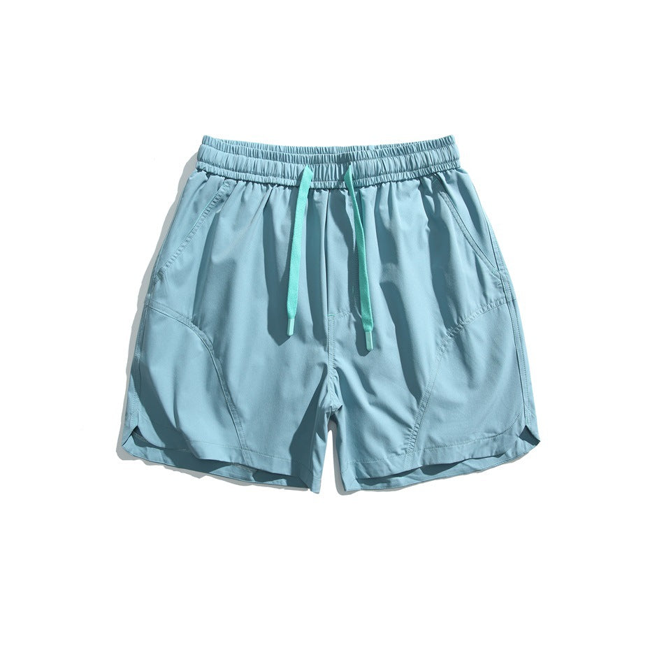 Light blue drawstring shorts with mint green cords, curved panel seams and side pockets, flat lay front view