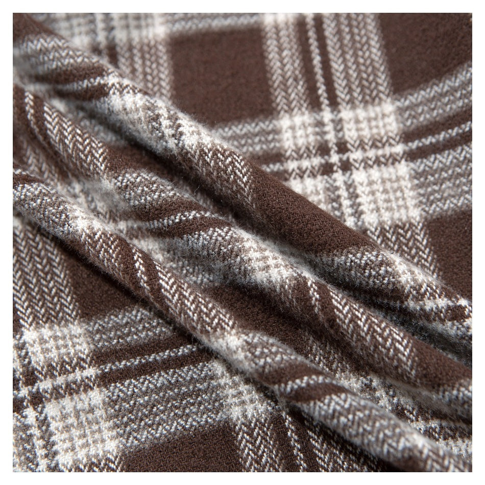 Close-up of the brown and cream plaid shirt fabric and its folded edge.