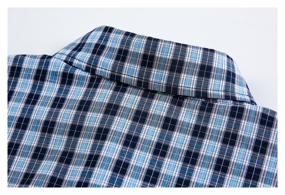 Close-up of the folded collar and upper back of a navy, light blue, and white plaid shirt.