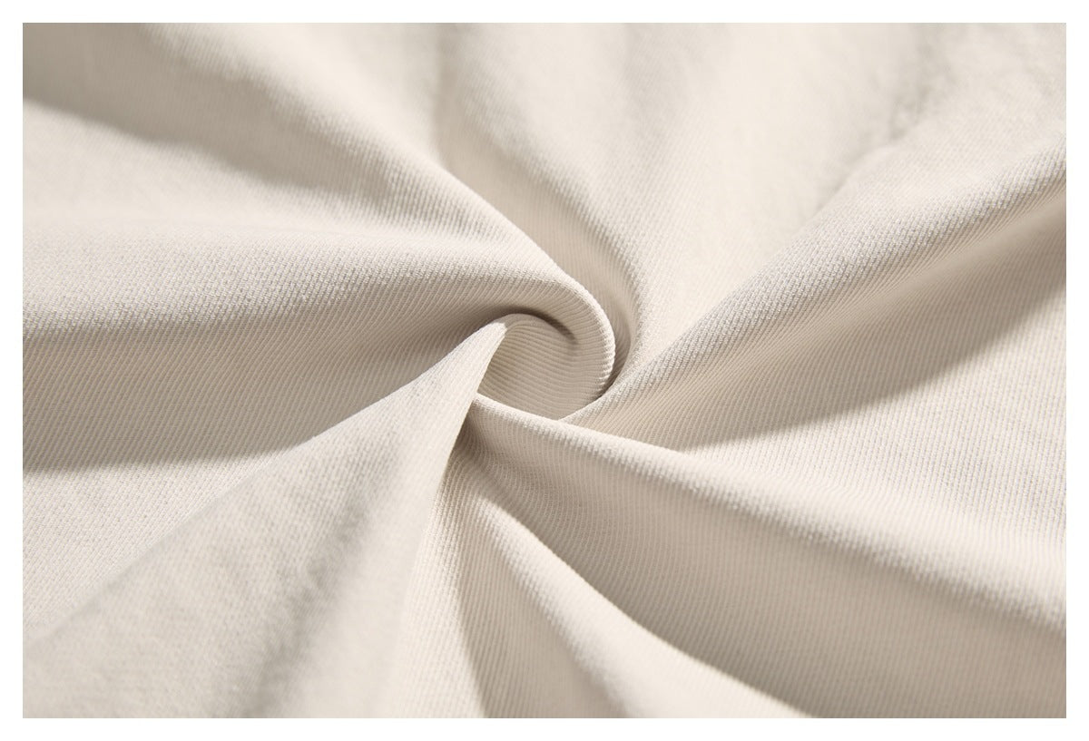 Close-up of pale cream twill fabric arranged in soft folds, showing its diagonal texture.