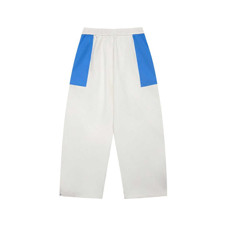 Back view of white pants with bright blue upper side panels and an elastic waistband.
