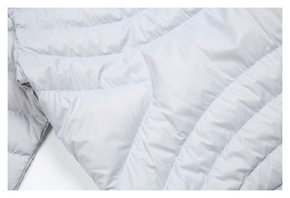 Close-up of pale gray jacket fabric with curved quilted panels and visible stitching.