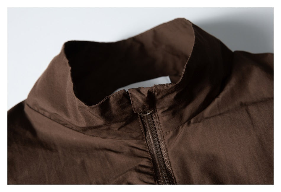 Close-up of the stand collar and front zipper of a dark brown jacket.