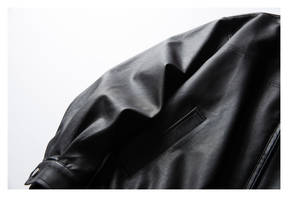 Close-up of a black jacket sleeve with snap-button cuff and a long rectangular detail on the panel.