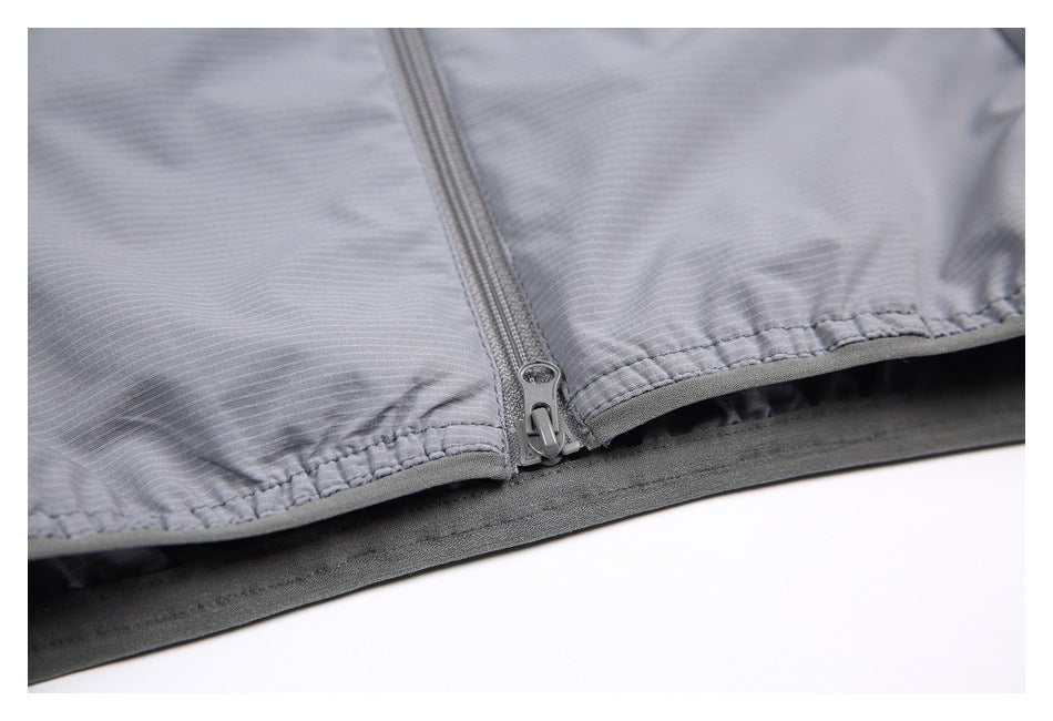 Close-up of the gray garment's main zipper and gathered lower edge.