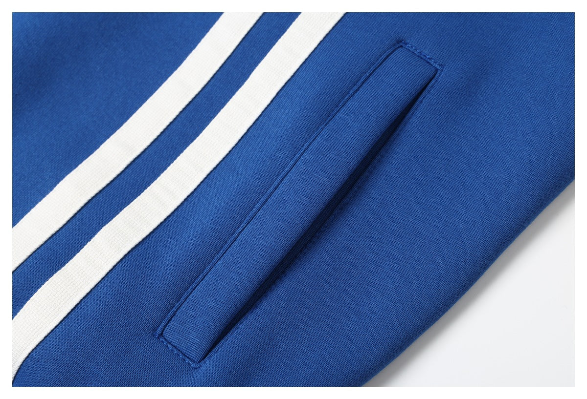 Close-up of a blue garment with two white stripes and a narrow welt pocket.