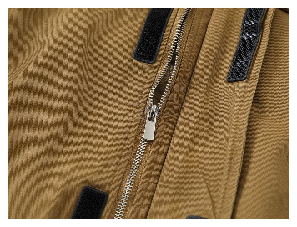 Close-up of a tan jacket with a silver zipper and black hook-and-loop fastening strips.