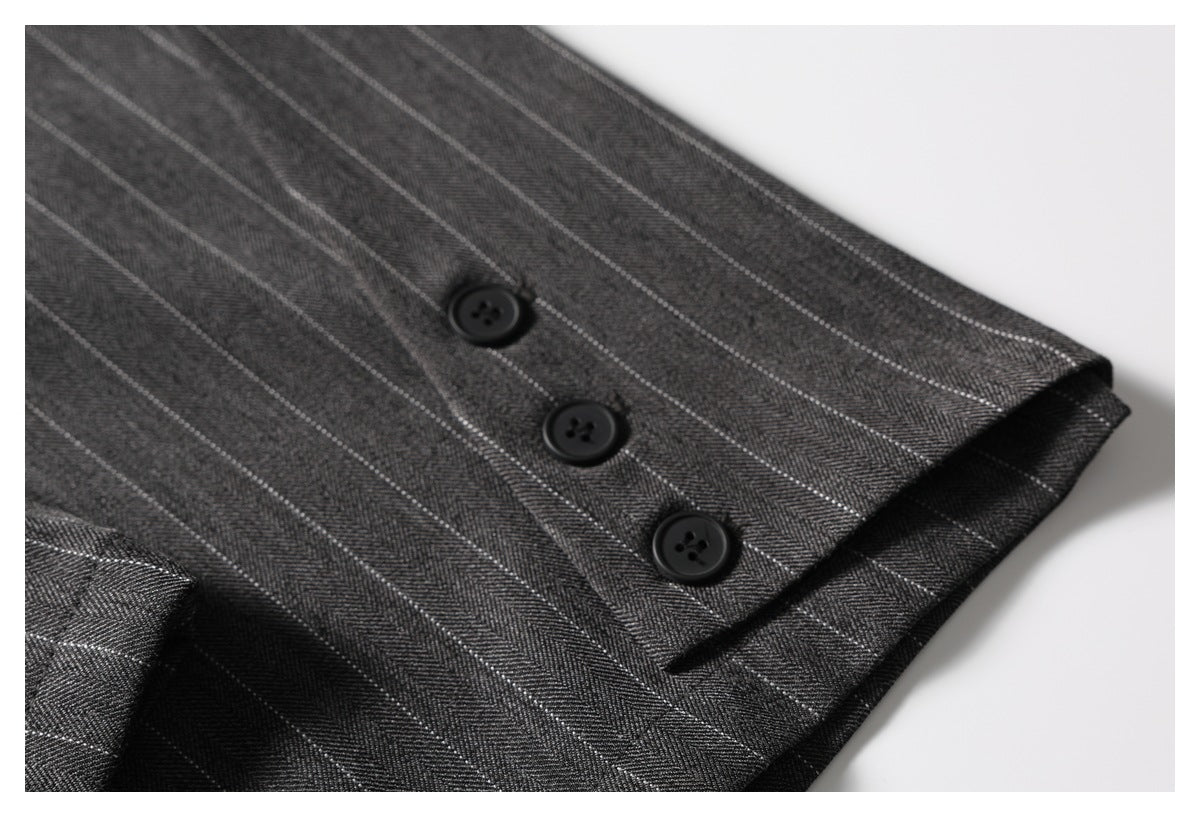 Close-up of three black buttons on a charcoal pinstripe garment edge.