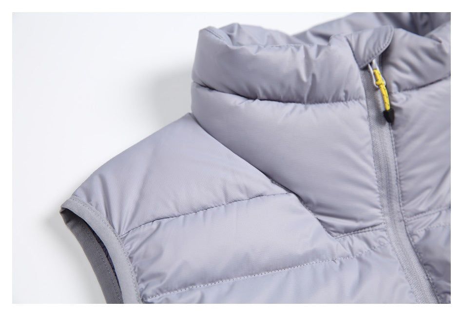 Close-up of a light gray-lavender quilted vest with a high collar, armhole binding and yellow zipper pull.