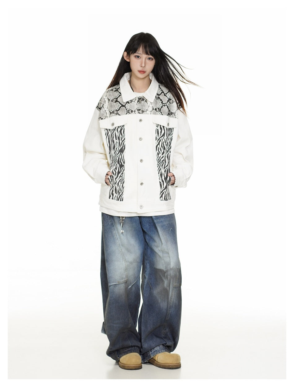 Model wearing a white button-front jacket with snakeskin and zebra-print panels, loose blue jeans, and tan shoes.