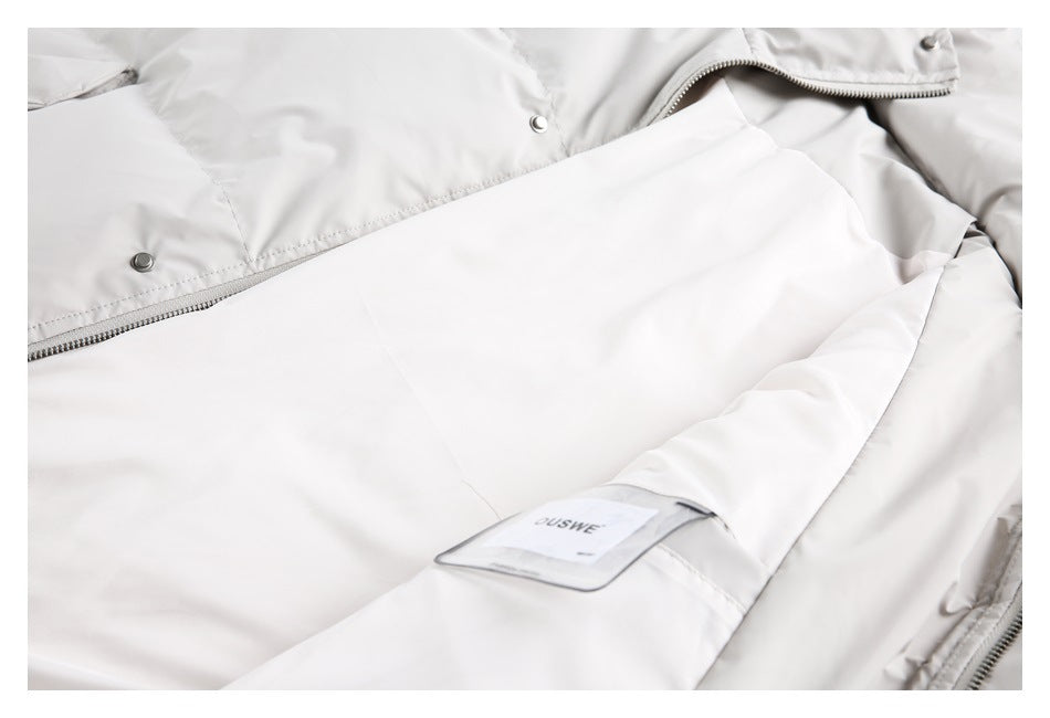 Close-up of the pale jacket interior, showing lining, zipper, snap fasteners, and a sewn-in label.