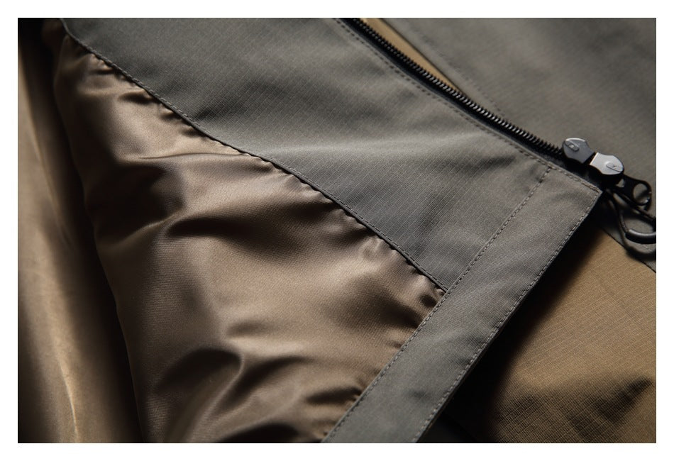 Close-up of a jacket interior showing brown lining, gray trim and a black zipper.