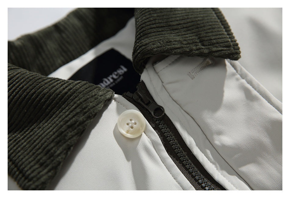 Close-up of a white jacket collar with dark ribbed trim, a button, and a zipper.