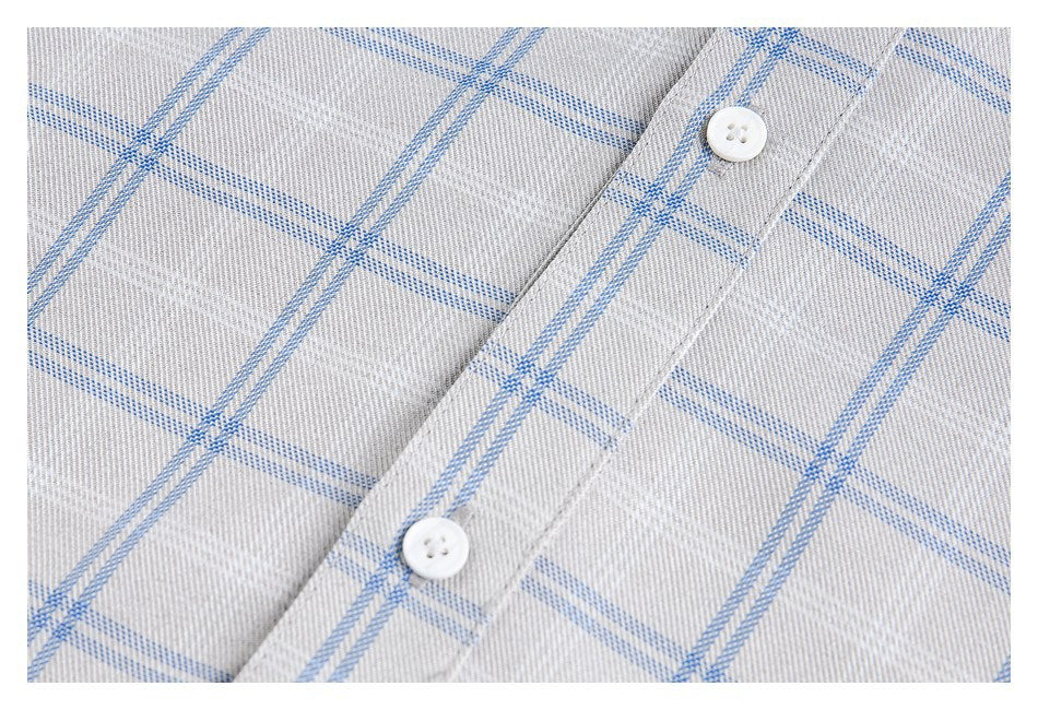Close-up of a light gray shirt placket with two white buttons and a blue windowpane check.
