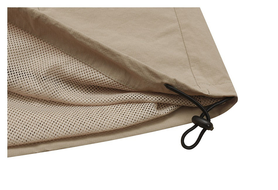 Close-up of a beige garment edge with mesh lining and a black elastic drawcord with toggle.