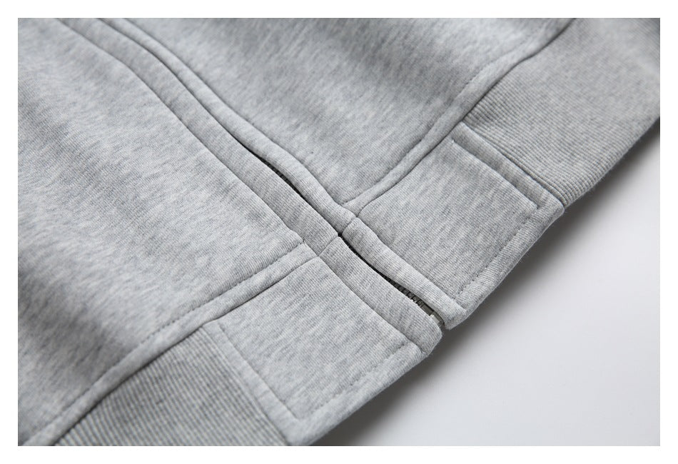 Gray heather garment detail showing a front zipper meeting a ribbed hem band.